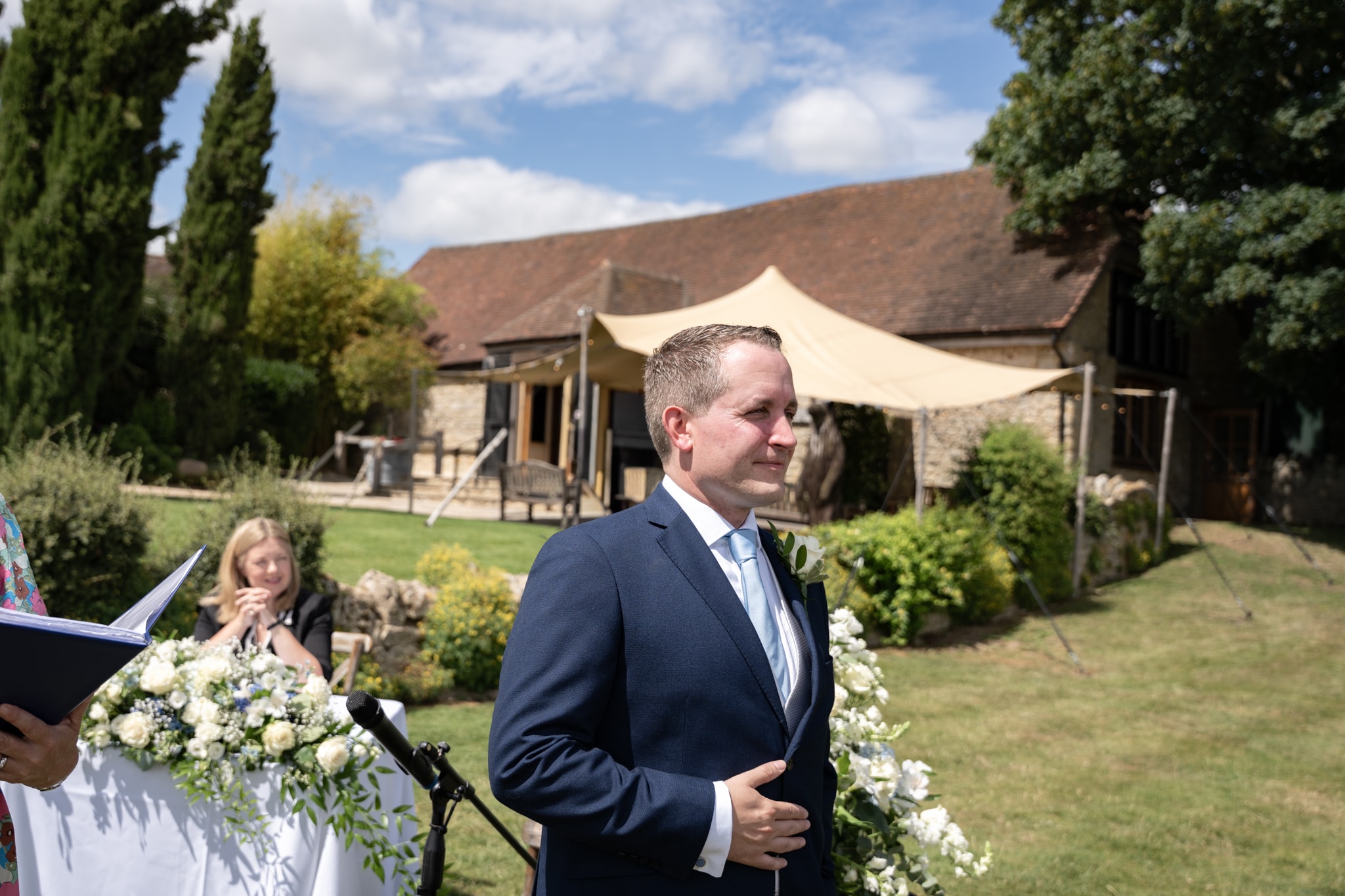 Groom waiting at outdoor ceremony at Notley Tythe Barn