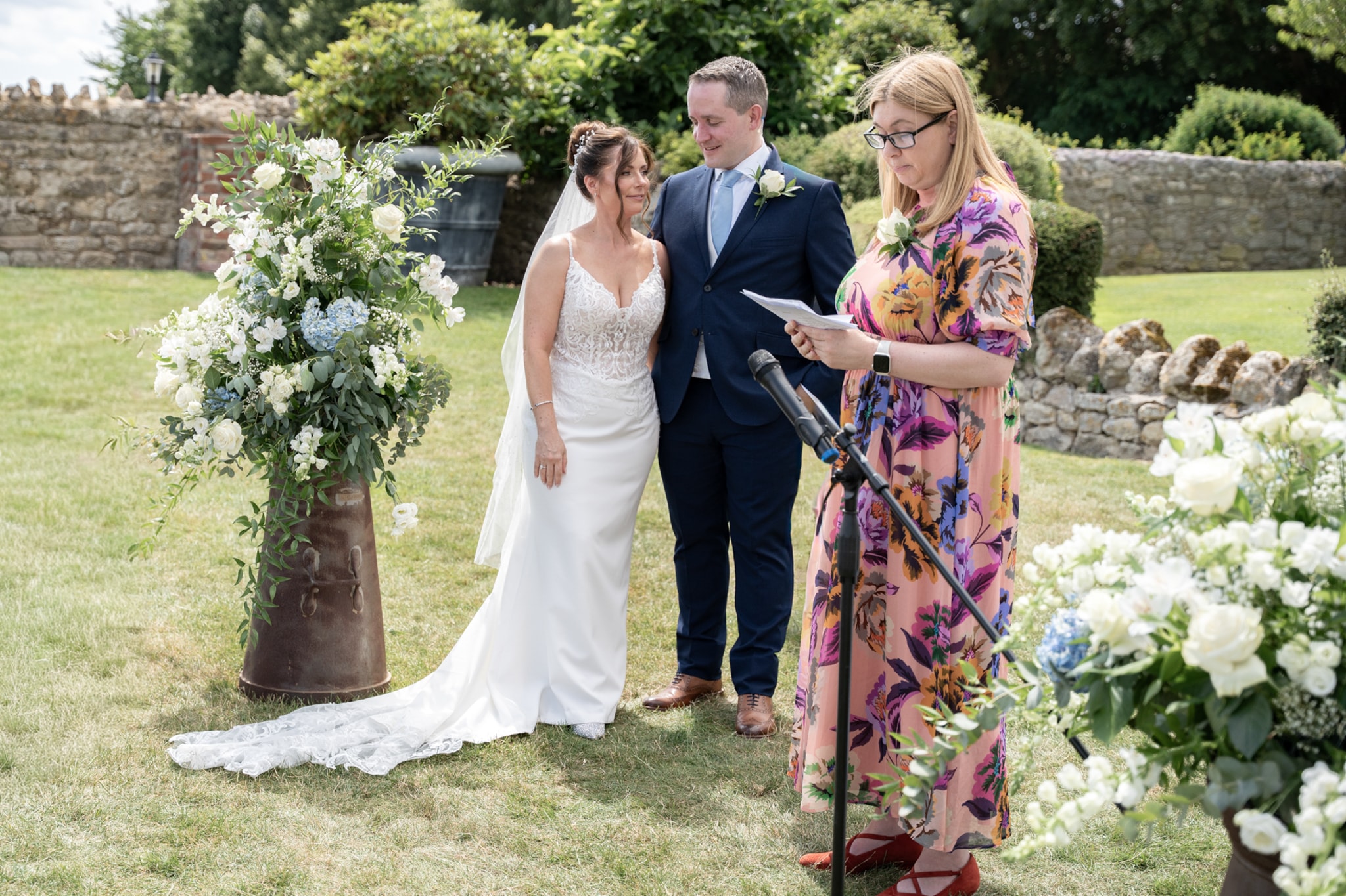 Bride and groom listening to officiant at outdoor Notley Tythe Barn ceremony