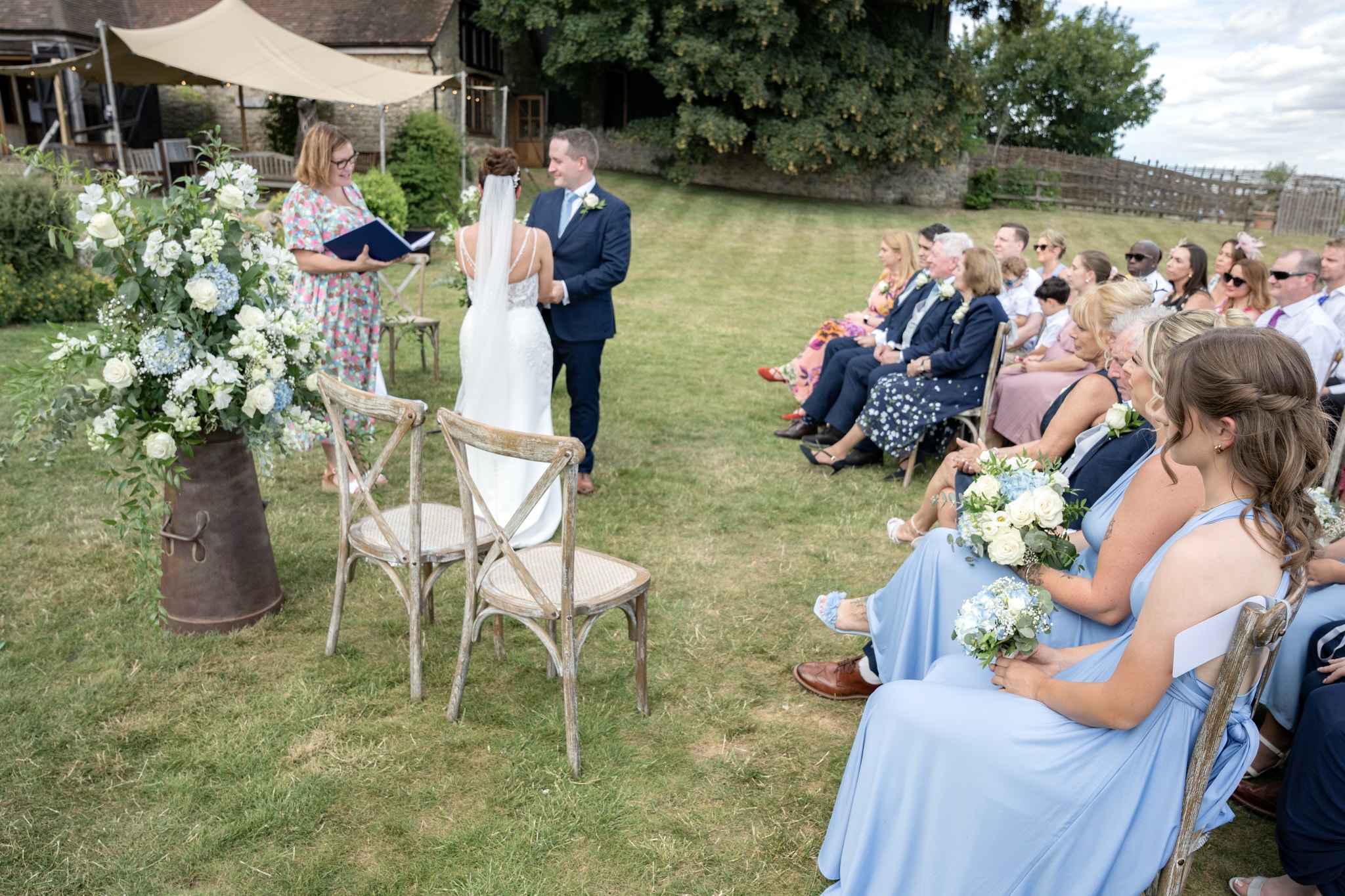 Wide view of outdoor wedding ceremony with guests at Notley Tythe Barn