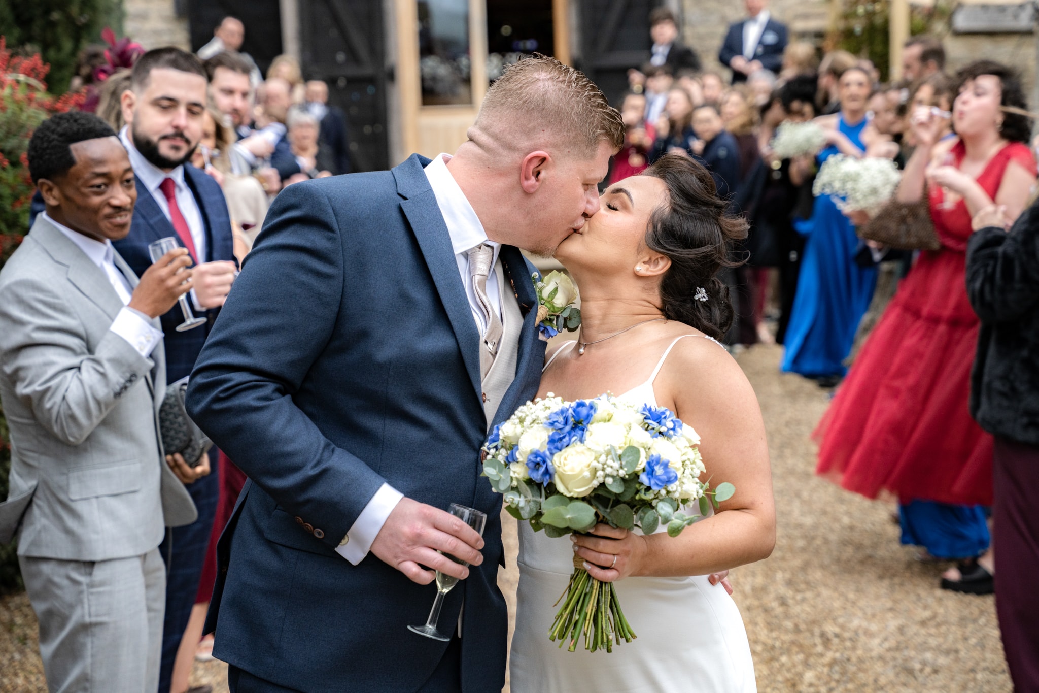 Bride and groom kissing at Notley Tythe Barn wedding reception