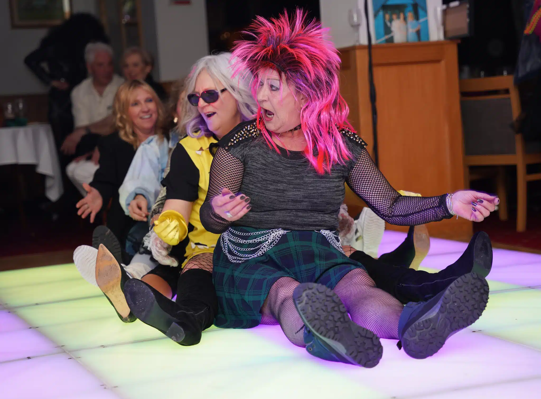 woman with pink hair sat on floor dancing