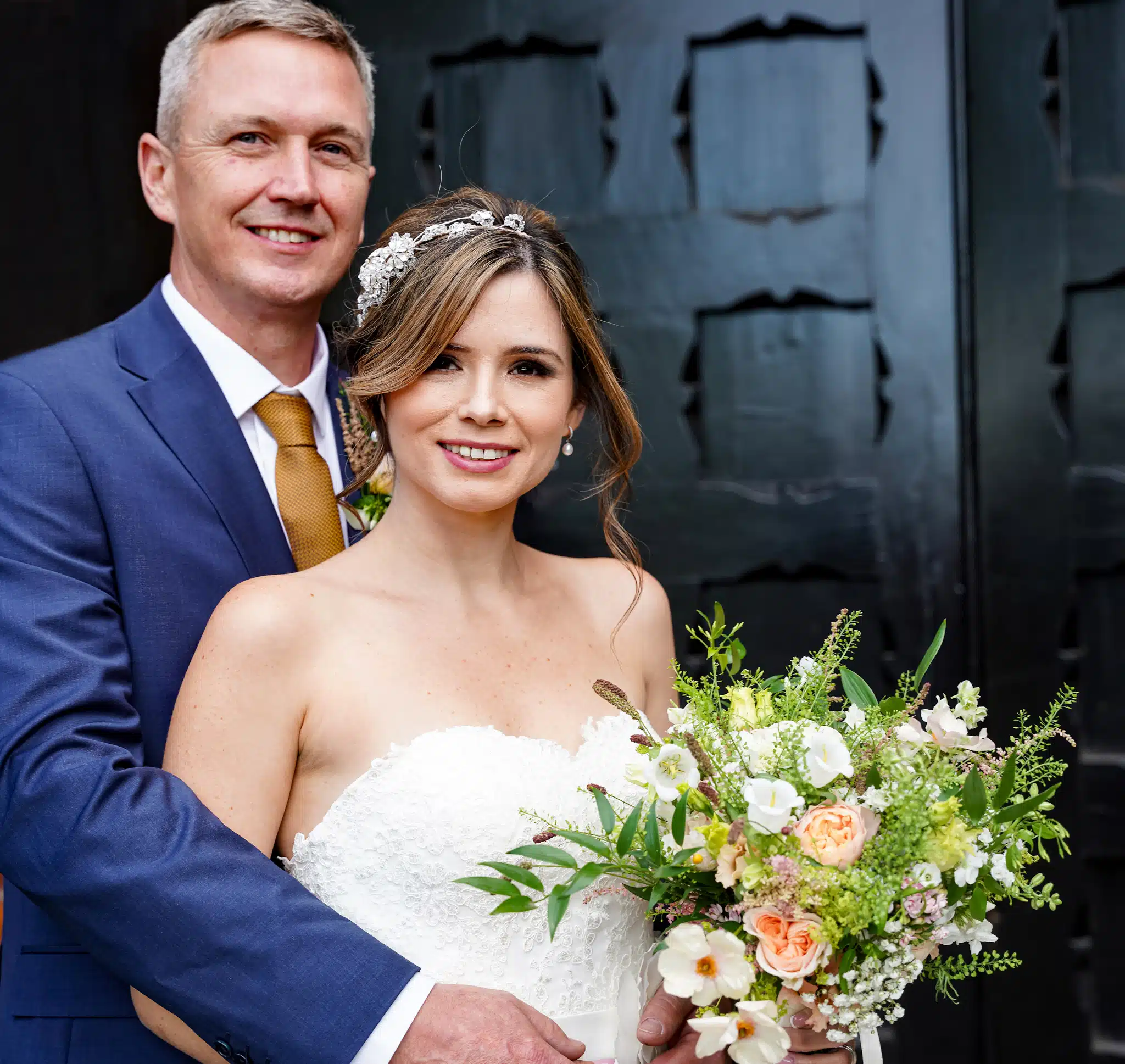 Bride and groom by black door of st albans registry office