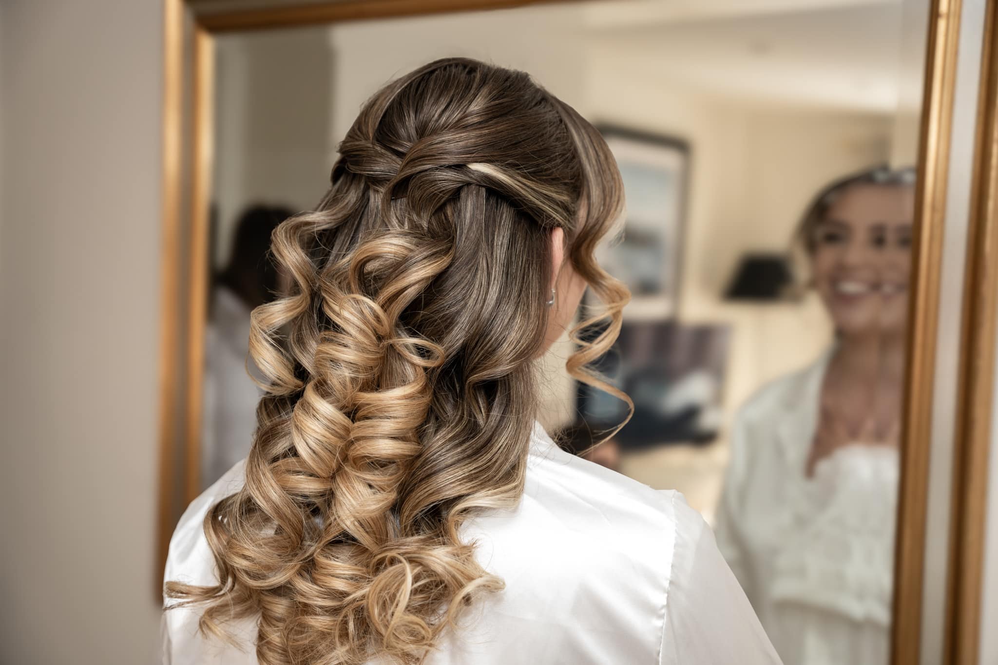 bride getting ready and looking in mirror