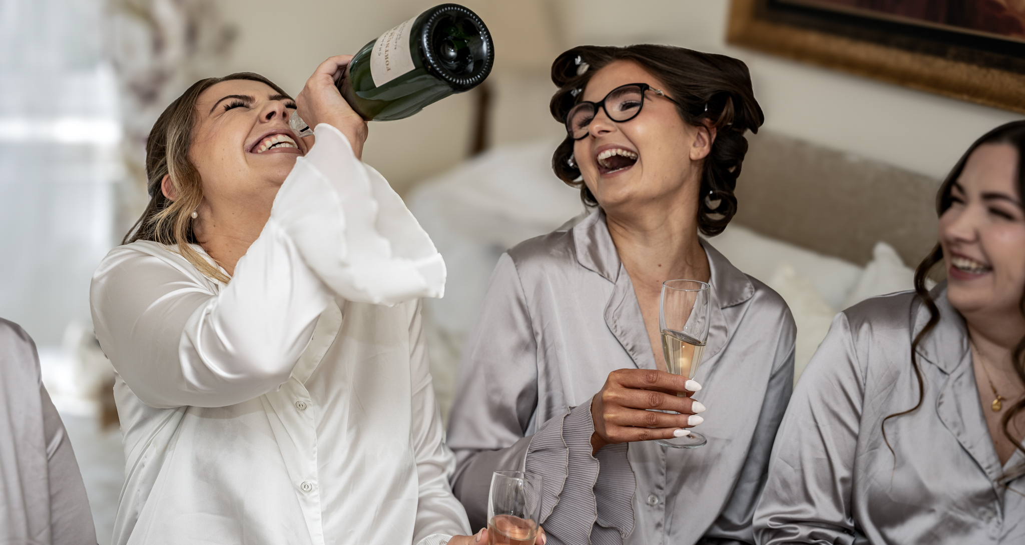 bride laughting holding a bottle of champagne