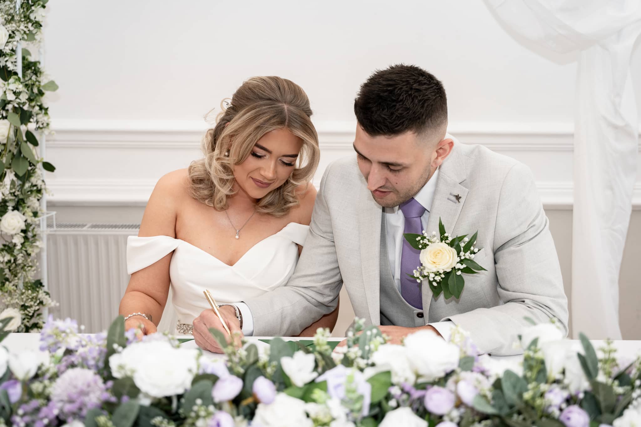 bride and groom signing registrar 