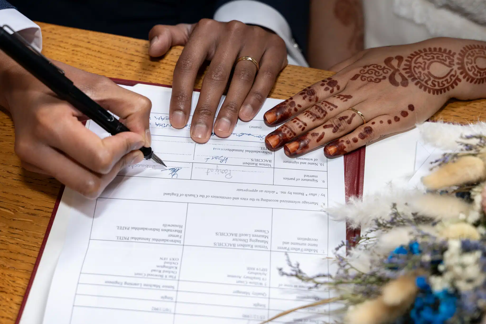 Asian bride and groom signing registrar 