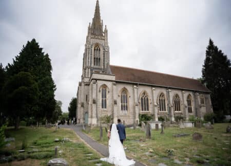 bride and groom walking towards all saints church marlow