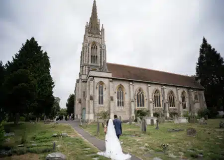 bride and groom walking towards all saints church marlow