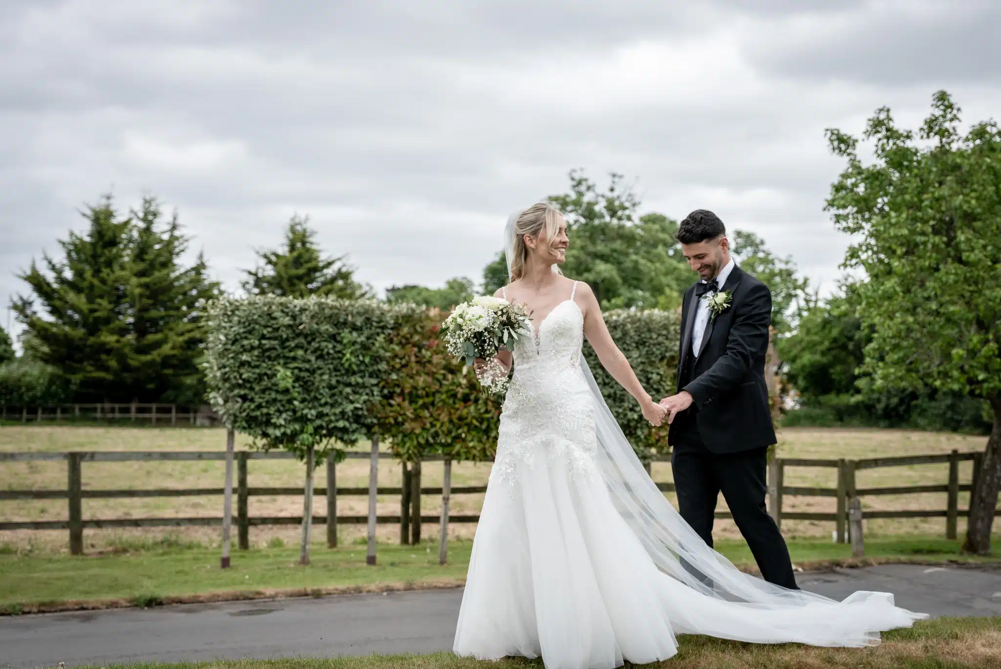 Bride and Groom walking and holding hands at Tudor Barn