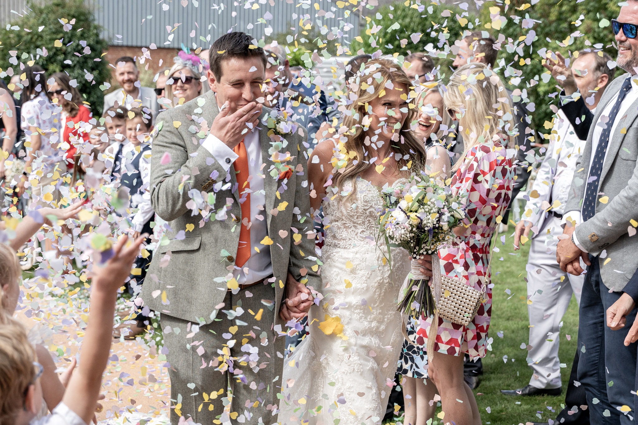 bride and groom under confetti