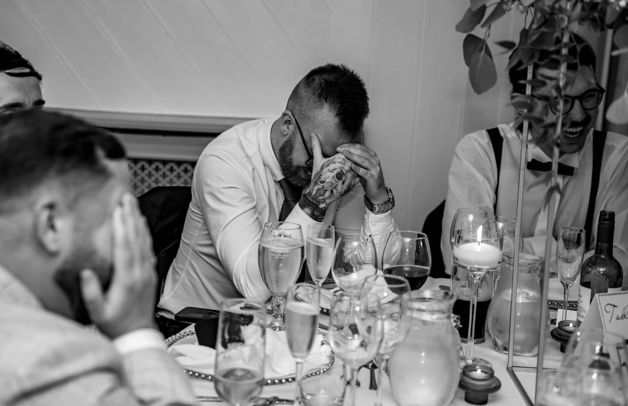 man laughing at wedding speeches
