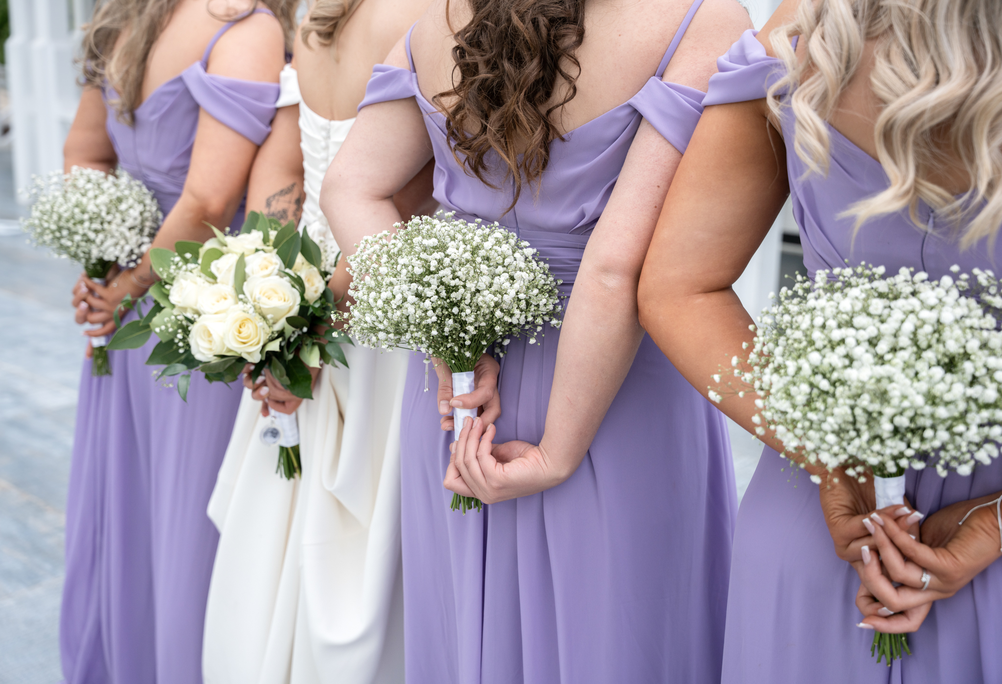 Bridesmaids in lavender dresses with whte bouquets 