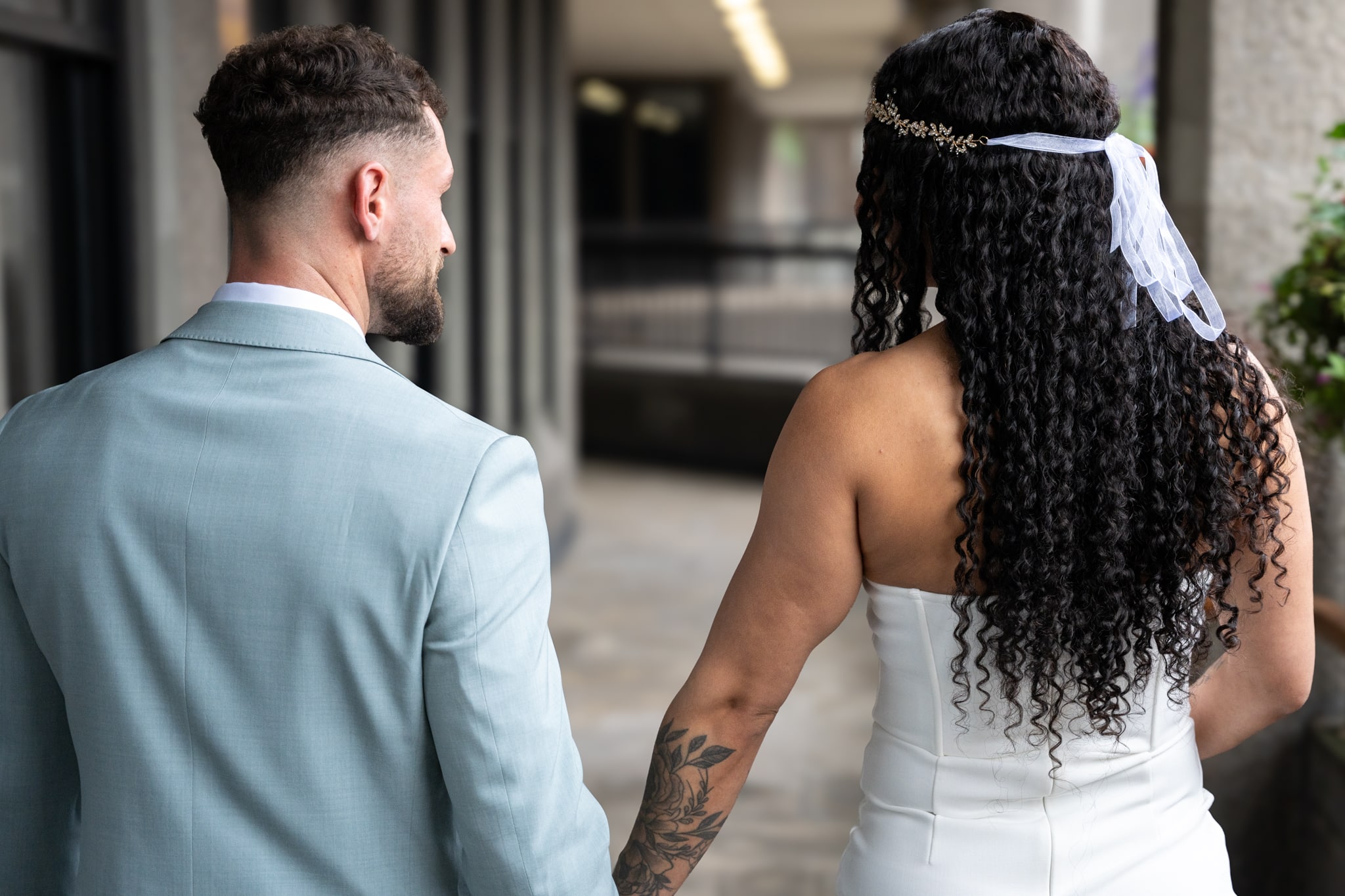 Bride and groom walking away from aylesbury registry office. holding hands