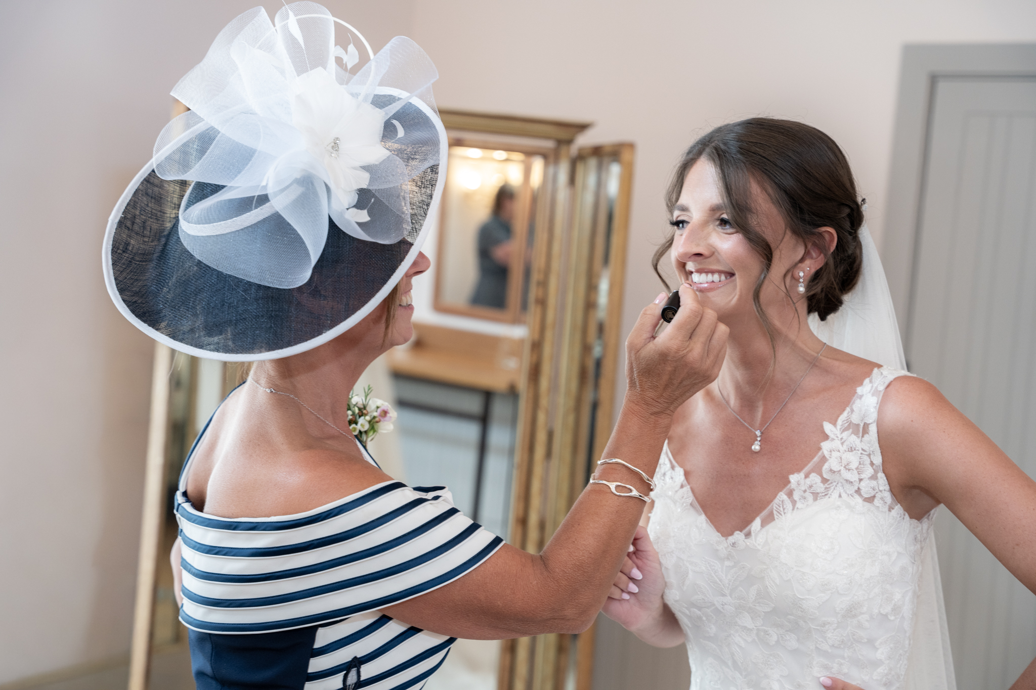 bridal prep mother putting lipstick on the bride