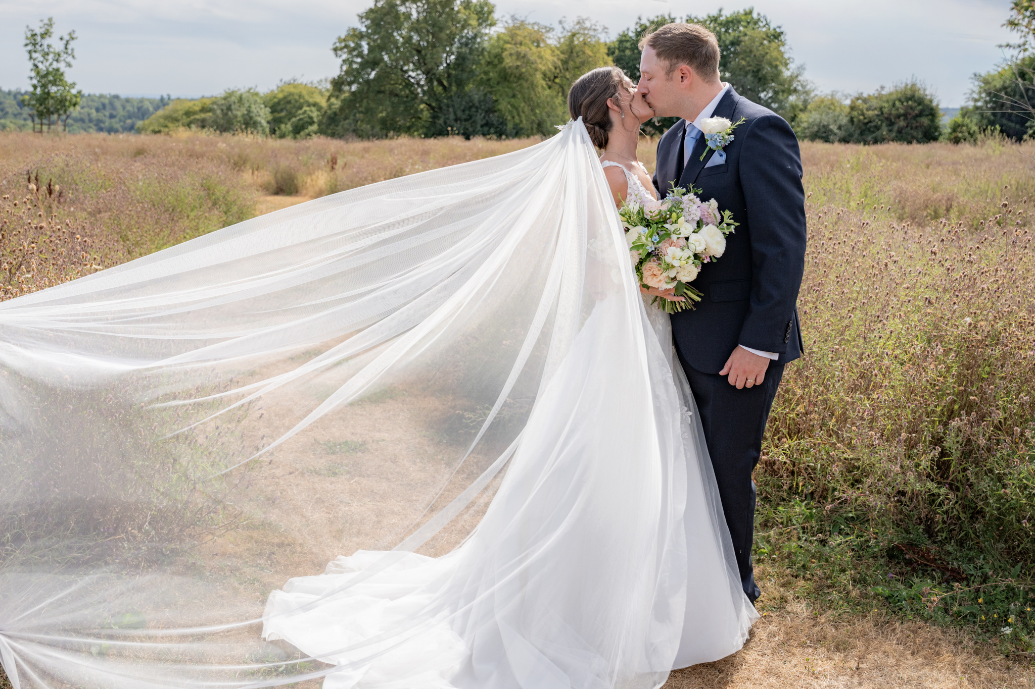 Bride with long veil blowing int he wind at Rackleys barn, Chiltern Hills