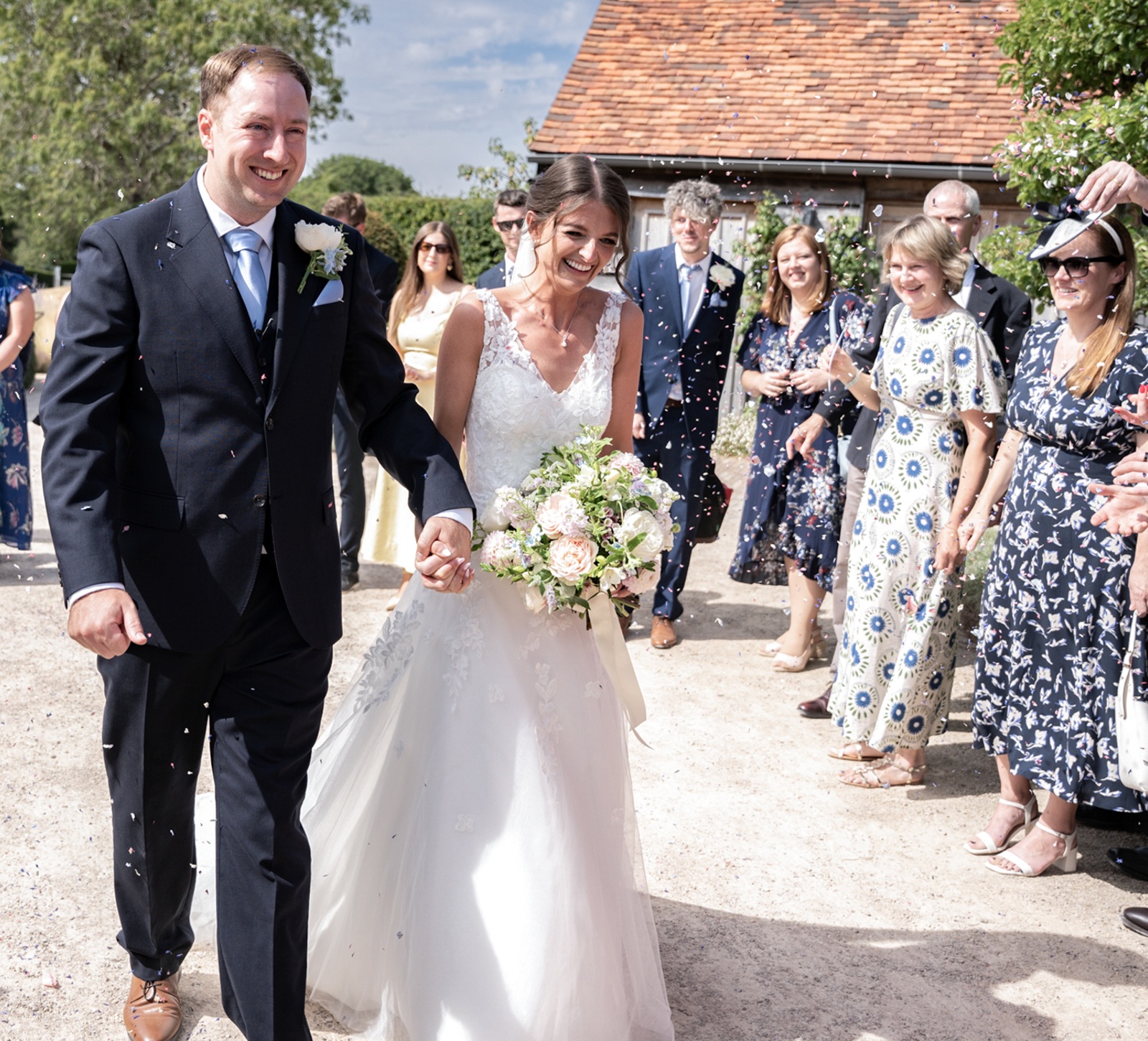 bride and groom walking under confetti at Rackleys Barn